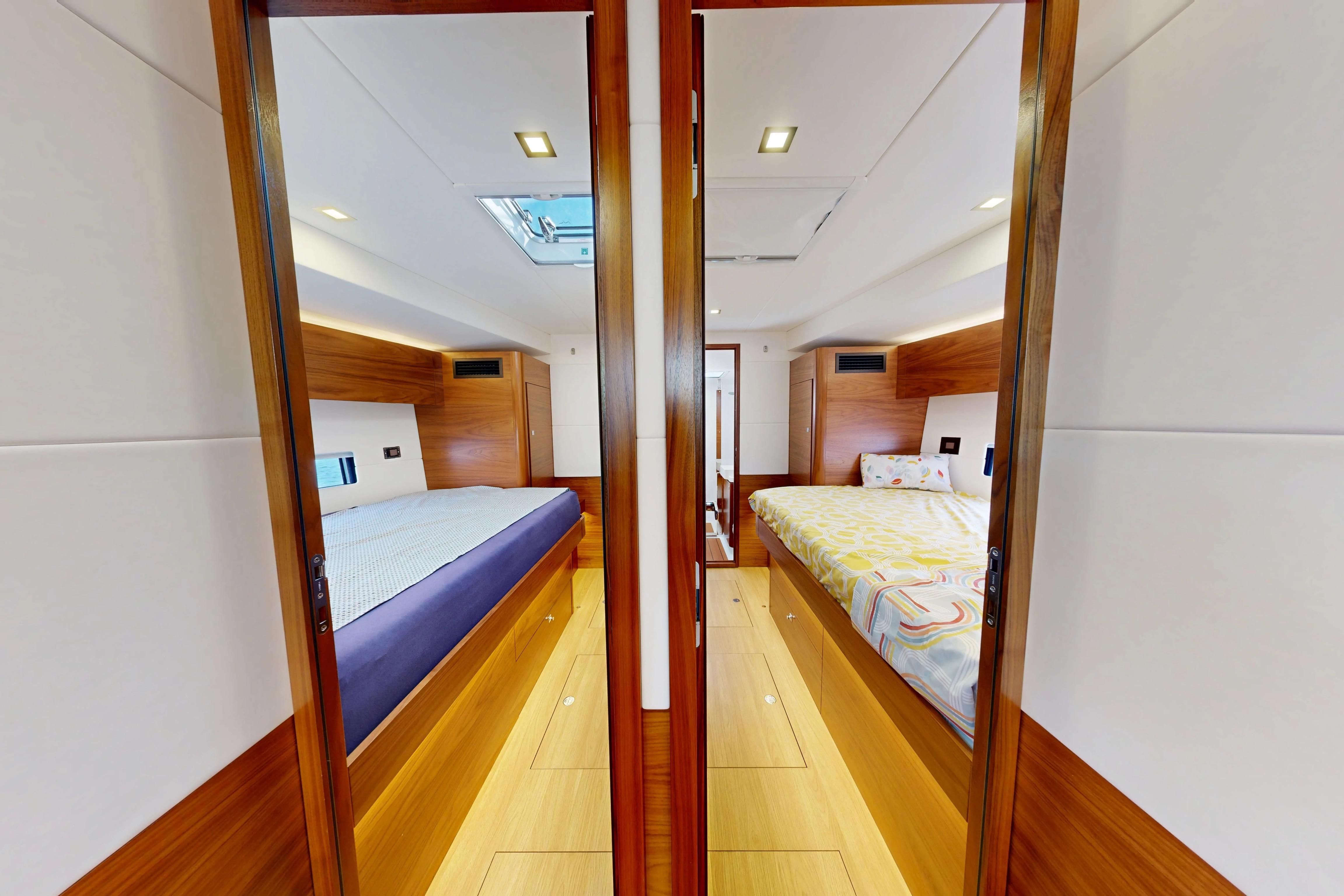 Luxurious 2024 Amel 60 yacht interior with twin cabins and modern wood finishes.