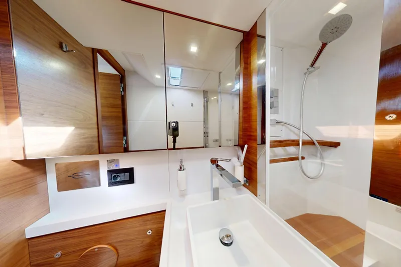  Yacht Photos Pics Luxurious bathroom in 2024 Amel 60 yacht with modern fixtures and wooden accents.