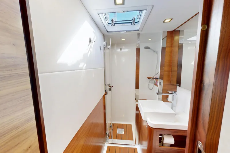  Yacht Photos Pics Luxurious bathroom interior of 2024 Amel 60 yacht with modern fixtures and wooden accents.