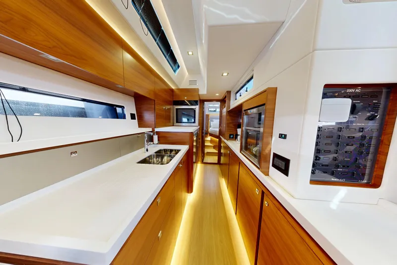  Yacht Photos Pics Luxurious interior of 2024 Amel 60 yacht, featuring modern kitchen and sleek wood finishes.