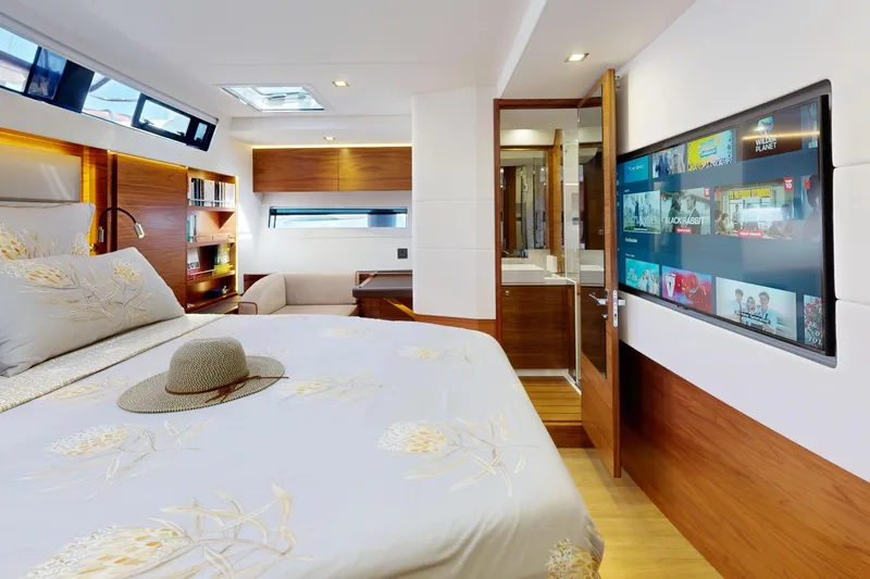  Yacht Photos Pics Luxurious 2024 Amel 60 yacht bedroom with modern decor and entertainment system.