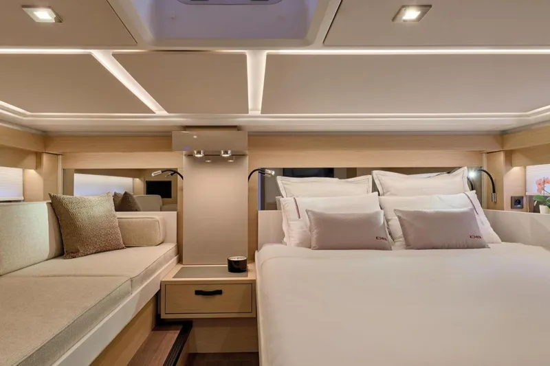  Yacht Photos Pics Luxurious interior of 2025 Jeanneau DB/43 IB yacht with elegant bedding and seating.