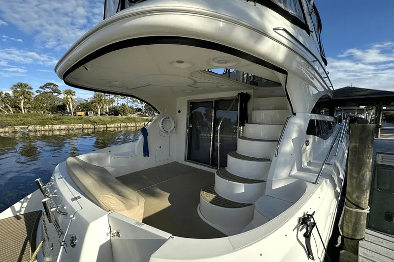  Yacht Photos Pics 2015 Meridian 441 Sedan yacht with elegant deck and spiral staircase, docked by serene waters.