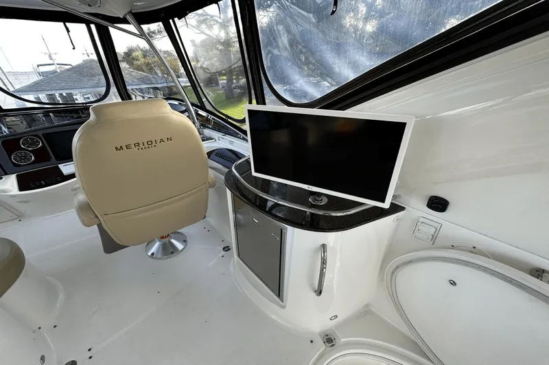  Yacht Photos Pics Interior of 2015 Meridian 441 Sedan yacht with helm chair and mounted TV.