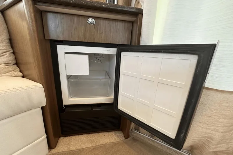  Yacht Photos Pics Open mini fridge inside 2015 Meridian 441 Sedan, showcasing interior storage space.