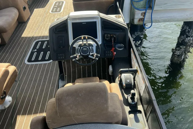  Yacht Photos Pics 2023 Premier 330 Escalante boat cockpit with steering wheel and controls by the water.