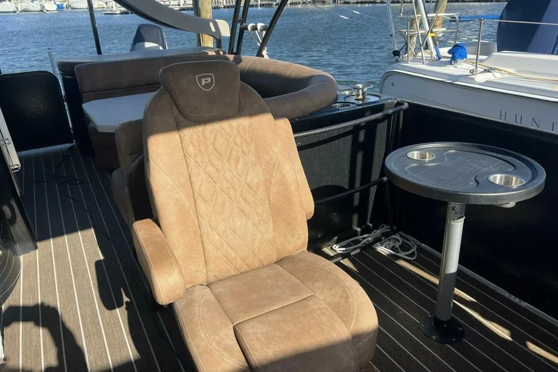  Yacht Photos Pics Luxurious seating on 2023 Premier 330 Escalante boat with table, docked by the water.