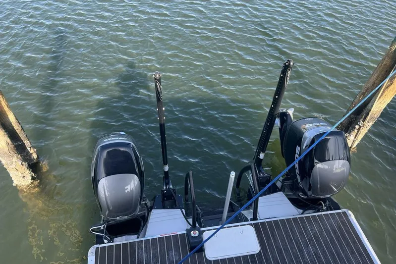  Yacht Photos Pics 2023 Premier 330 Escalante boat engines on water, docked between wooden posts.