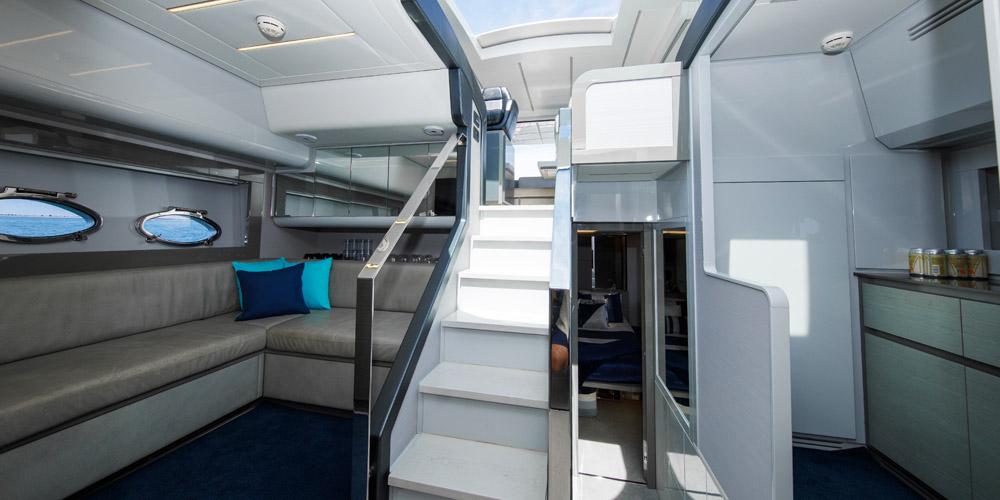 Luxurious interior of 2015 Pershing 62' yacht with modern seating and elegant staircase.