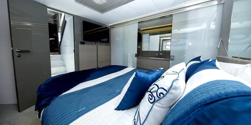  Yacht Photos Pics Luxurious bedroom interior of 2015 Pershing 62' yacht with blue and white decor.