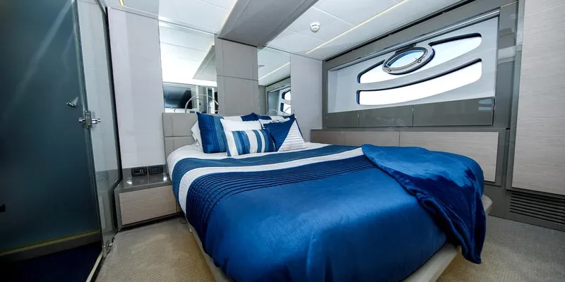  Yacht Photos Pics Luxurious bedroom interior on 2015 Pershing 62' yacht with blue bedding and modern design.