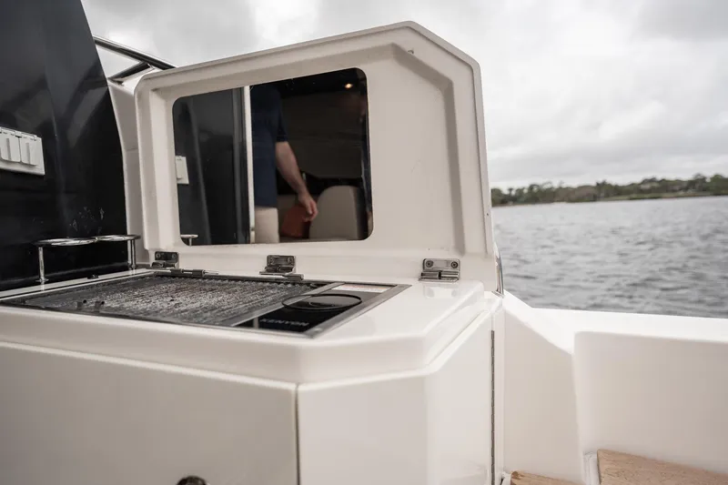 Sol E Mar IV Yacht Photos Pics Outdoor grill on 2015 Sea Ray 510 Sundancer yacht, overlooking water.
