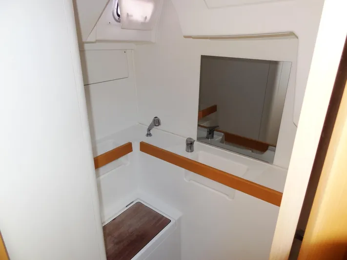 America Yacht Photos Pics 2018 Beneteau Oceanis 38 bathroom with sink, mirror, and storage compartments.