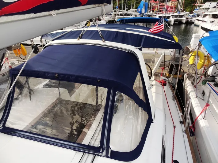 America Yacht Photos Pics 2018 Beneteau Oceanis 38 sailboat docked at marina with blue canopy.