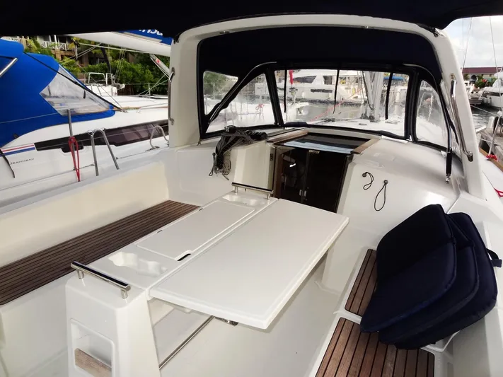 America Yacht Photos Pics 2018 Beneteau Oceanis 38 cockpit with seating and table, docked at marina.