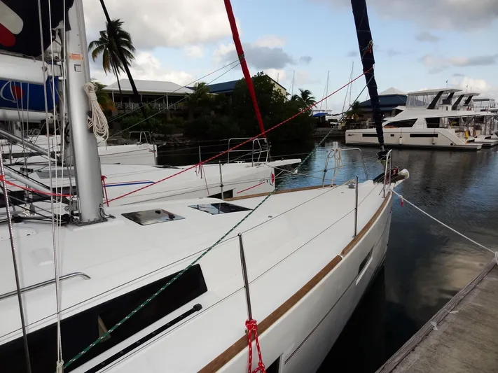 America Yacht Photos Pics 2018 Beneteau Oceanis 38 sailboat docked in a marina with other boats.