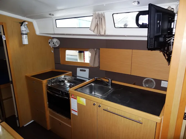 America Yacht Photos Pics Modern kitchen area in 2018 Beneteau Oceanis 38 sailboat with stove, sink, and storage.