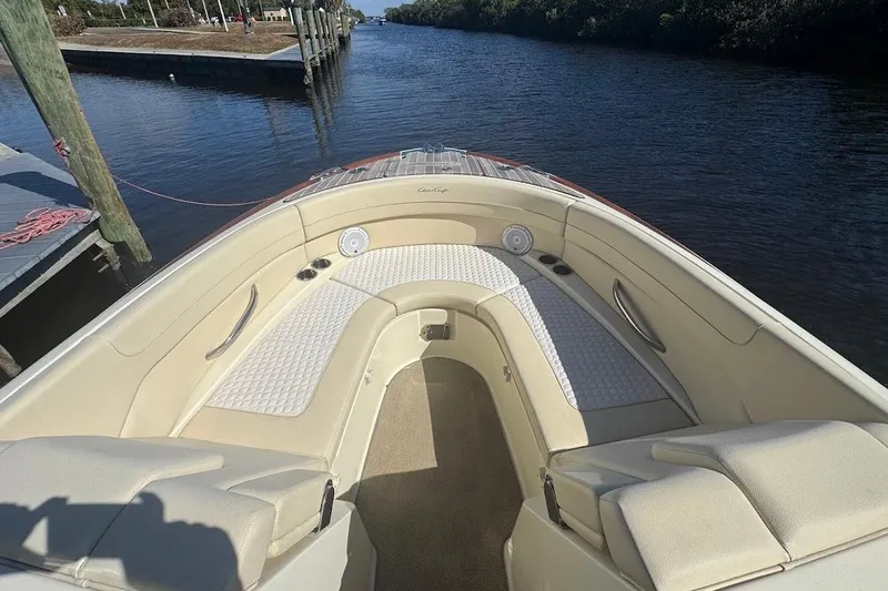  Yacht Photos Pics 2020 Chris-Craft Launch 28 boat interior with beige seating, docked by a calm river.