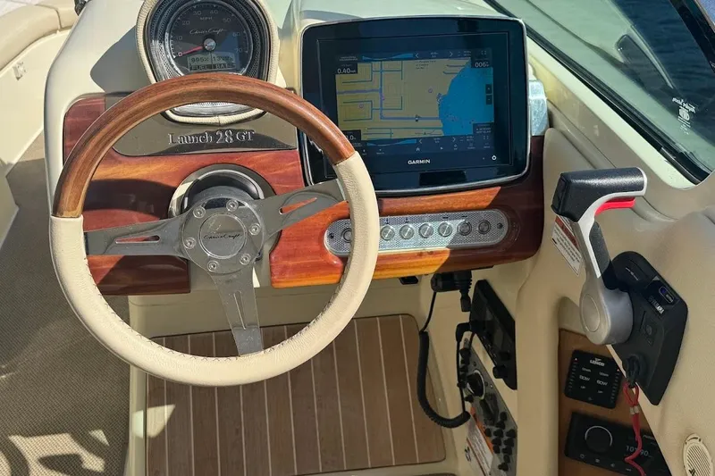  Yacht Photos Pics 2020 Chris-Craft Launch 28 dashboard with Garmin navigation and classic wooden steering wheel.
