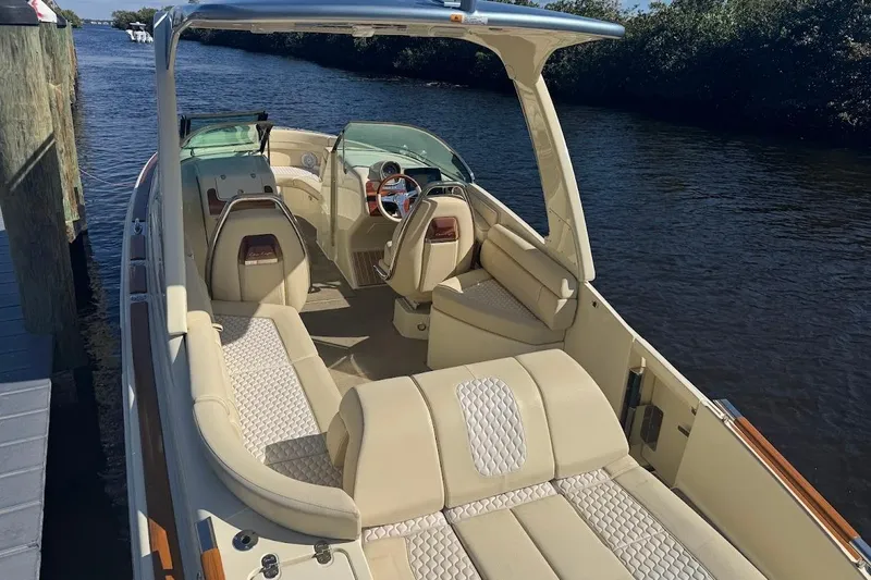  Yacht Photos Pics 2020 Chris-Craft Launch 28 boat with luxurious seating, docked by a serene waterway.