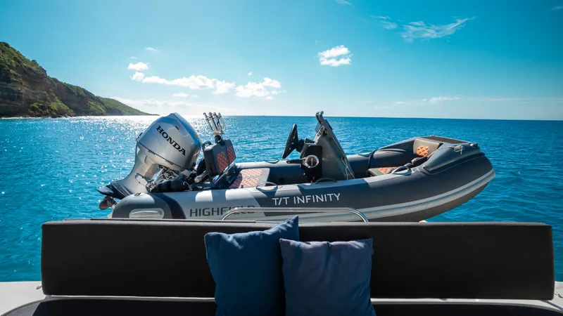 Infinity Yacht Photos Pics 2023 Lagoon 46 yacht with inflatable boat on serene blue ocean.