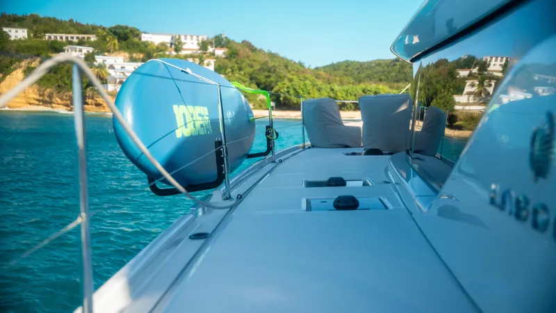 Infinity Yacht Photos Pics 2023 Lagoon 46 yacht on serene blue waters near a lush coastline.