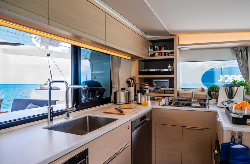 Infinity Yacht Photos Pics Modern kitchen interior of 2023 Lagoon 46 yacht with ocean view.