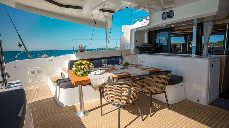 Infinity Yacht Photos Pics Luxurious 2023 Lagoon 46 yacht with elegant outdoor dining area and ocean view.