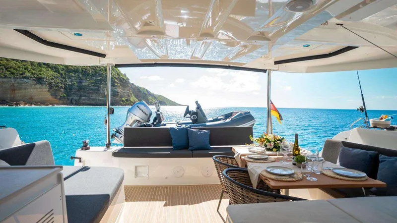 Infinity Yacht Photos Pics Luxurious Lagoon 46 yacht interior with ocean view, set dining table, and scenic coastline, 2023 model.