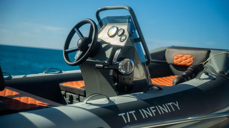 Infinity Yacht Photos Pics Steering console of a 2023 Lagoon 46 boat with orange seating, ocean in background.