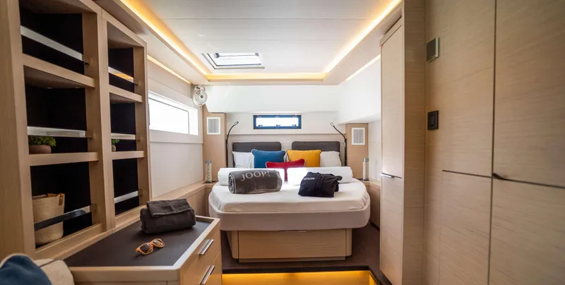 Infinity Yacht Photos Pics Luxurious interior of 2023 Lagoon 46 yacht cabin with modern design and cozy bedding.
