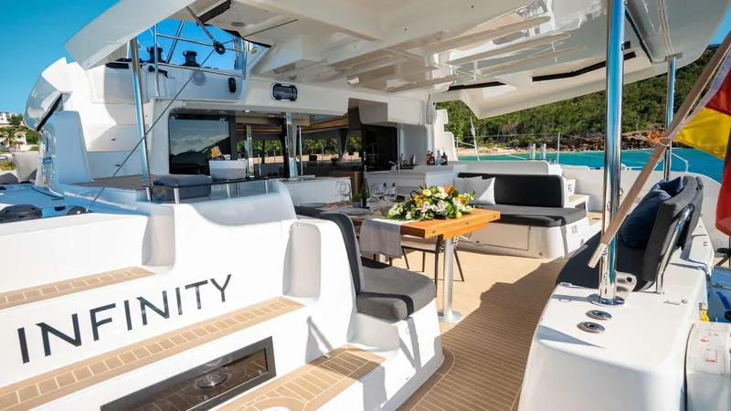 Infinity Yacht Photos Pics Luxurious 2023 Lagoon 46 yacht with elegant outdoor seating and dining area.