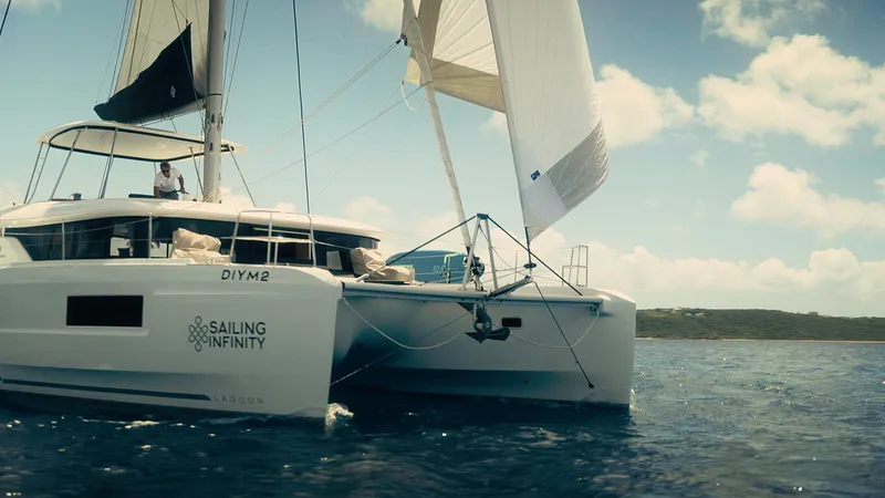 Infinity Yacht Photos Pics 2023 Lagoon 46 catamaran sailing on open water under clear skies.