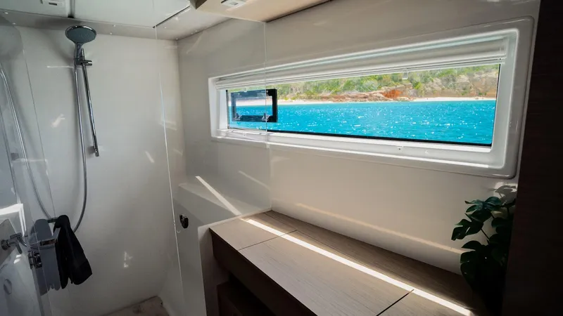 Infinity Yacht Photos Pics Modern bathroom interior of 2023 Lagoon 46 yacht with ocean view window.