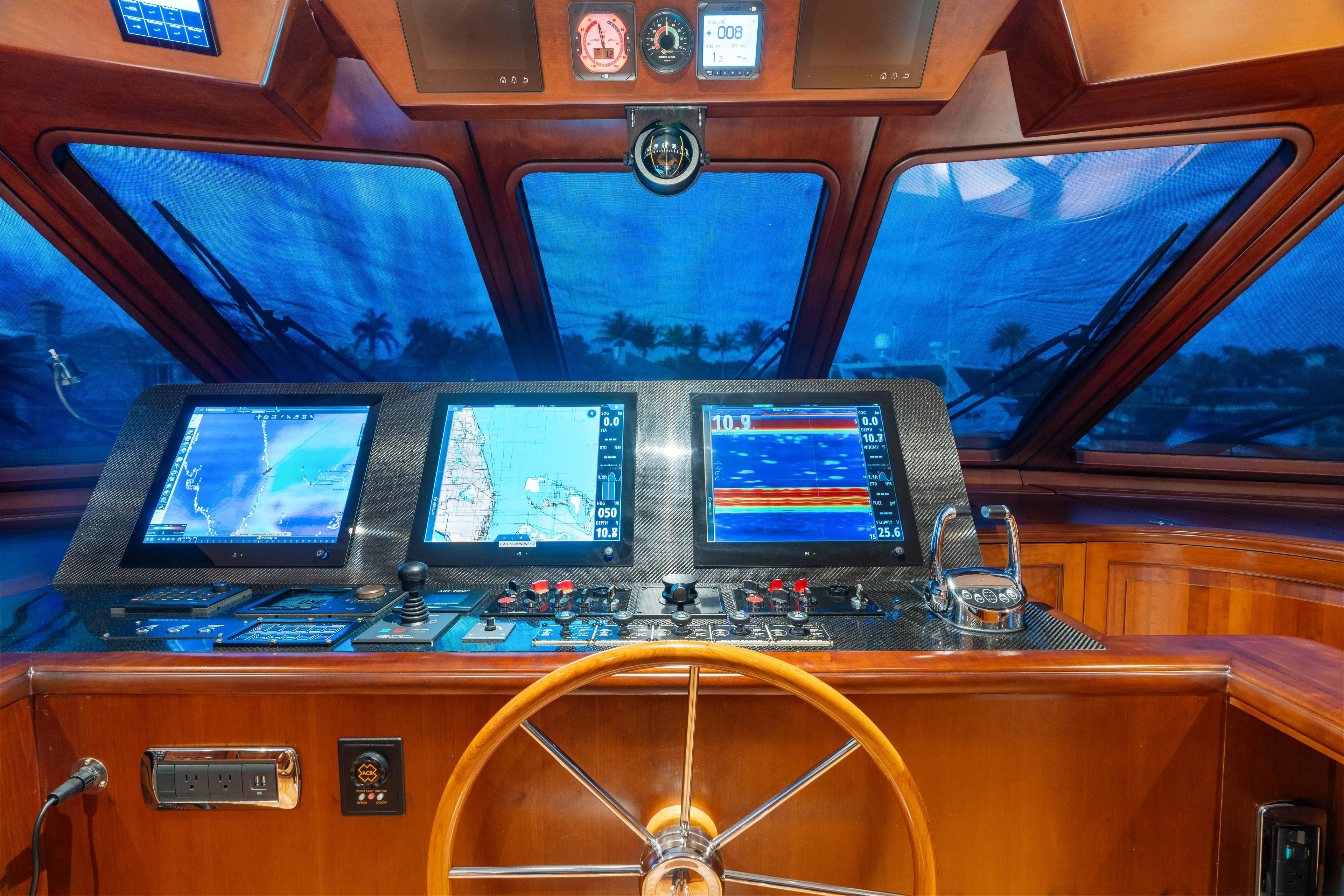 Driven Yacht Photos Pics Control panel of a 2005 Conrad 88 yacht with navigation screens and steering wheel.
