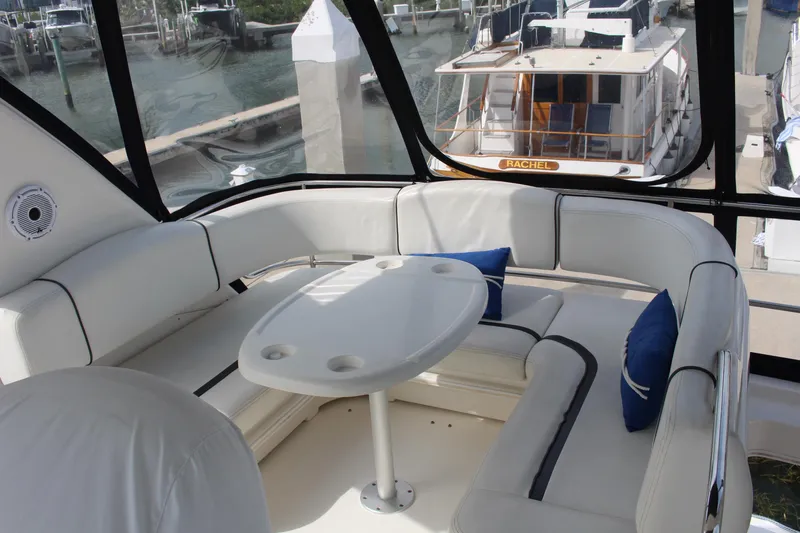 Passst Times Yacht Photos Pics 2005 Sea Ray 420 Sedan Bridge interior with white seating and table, docked at marina.