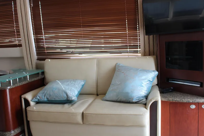 Passst Times Yacht Photos Pics Interior of 2005 Sea Ray 420 Sedan Bridge with beige sofa and blue cushions.