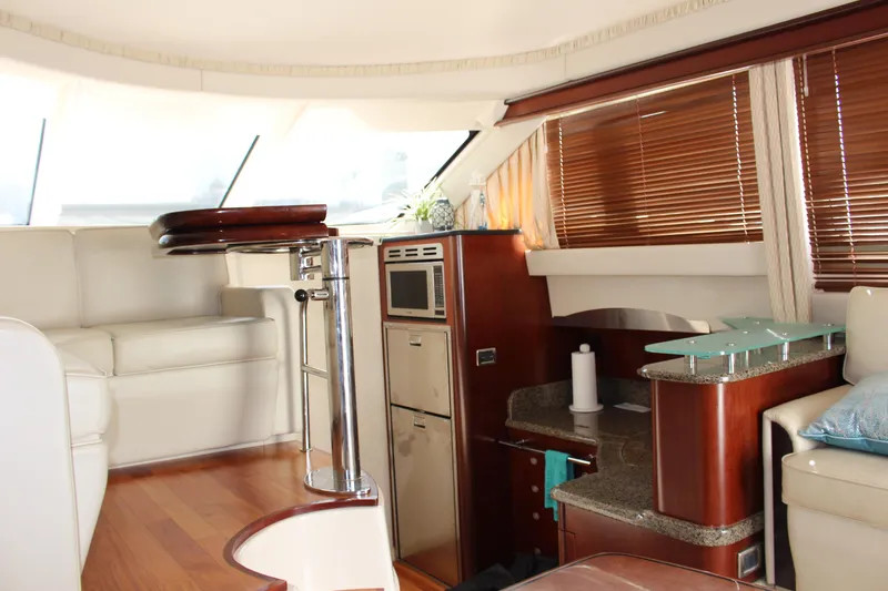 Passst Times Yacht Photos Pics Interior of 2005 Sea Ray 420 Sedan Bridge yacht with modern furnishings and wood accents.