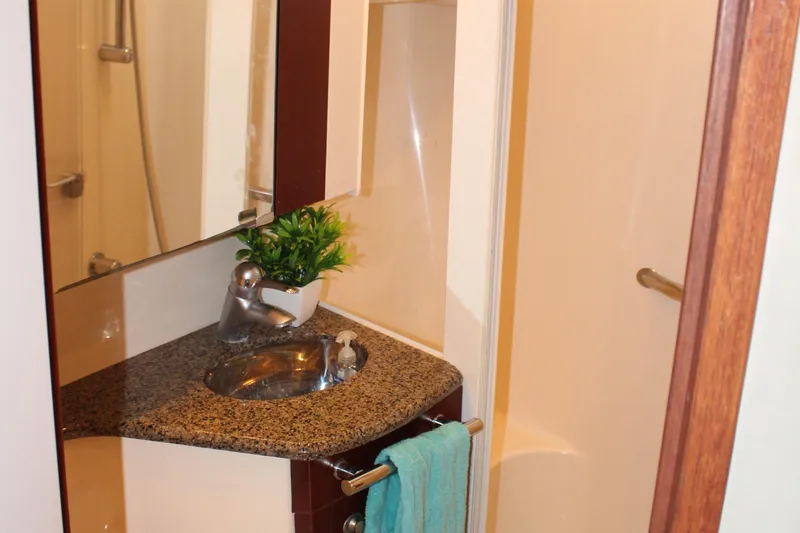 Passst Times Yacht Photos Pics Bathroom interior of 2005 Sea Ray 420 Sedan Bridge with granite countertop and modern fixtures.