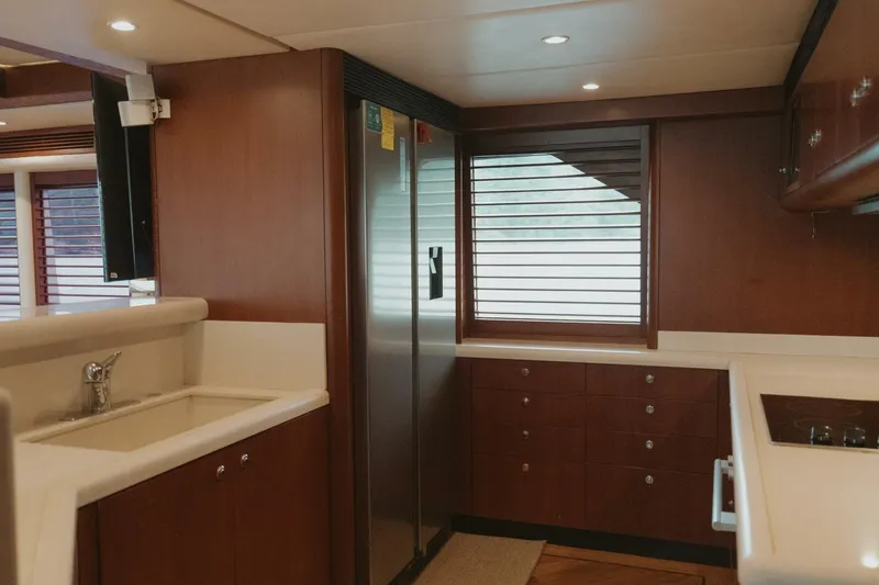 Aussie Rules Yacht Photos Pics Luxurious kitchen interior of 1996 Oceanfast 87 Enclosed Bridge yacht with wood cabinetry.