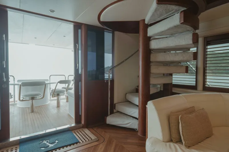 Aussie Rules Yacht Photos Pics Luxurious interior of 1996 Oceanfast 87 Enclosed Bridge yacht with spiral staircase and seating area.