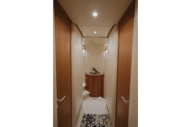 Aussie Rules Yacht Photos Pics Narrow hallway in 1996 Oceanfast 87 Enclosed Bridge yacht with wooden doors and modern lighting.
