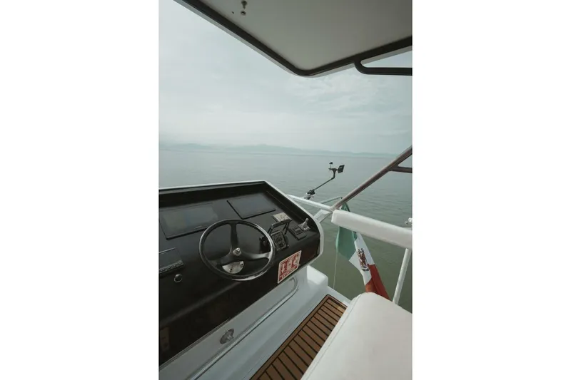 Aussie Rules Yacht Photos Pics 1996 Oceanfast 87 Enclosed Bridge yacht helm with ocean view and flag.