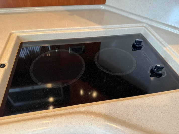  Yacht Photos Pics Stovetop in 2003 Sea Ray 380 Sundancer yacht kitchen, featuring sleek black design.