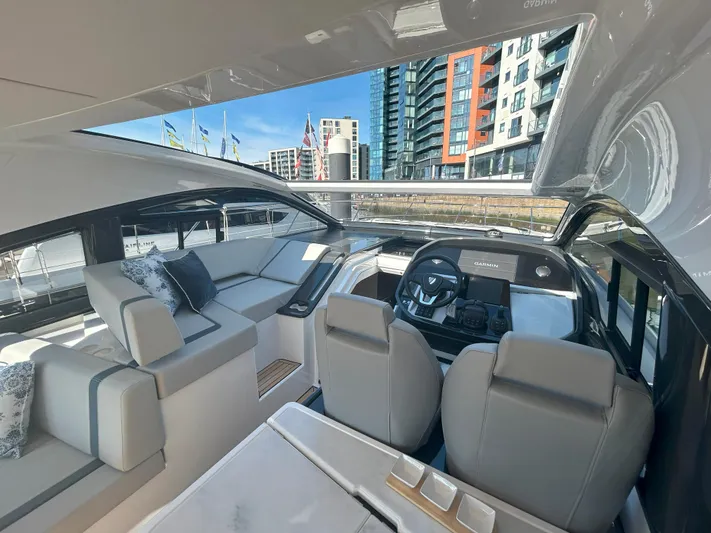 Mby Motor Boat Of The Year 2025 Yacht Photos Pics 2025 Fairline Targa 40 yacht interior with modern seating and helm, docked near urban buildings.