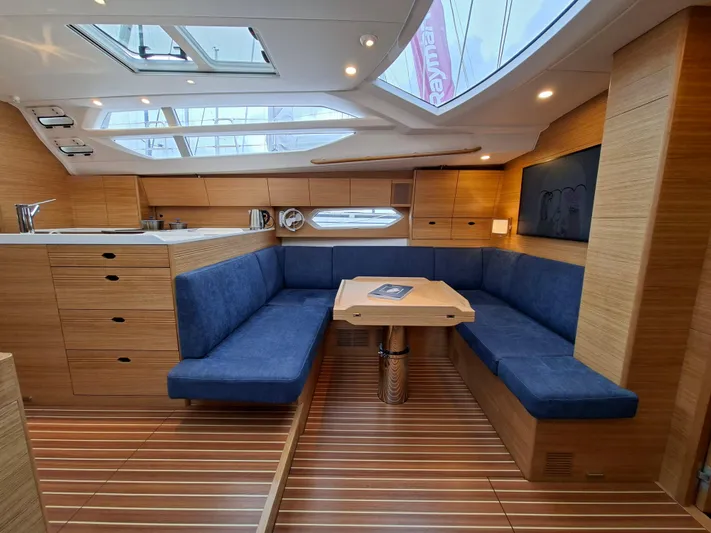 Yula Yacht Photos Pics Luxurious interior of 2024 X-Yachts Xc 47 with blue seating and wooden finishes.