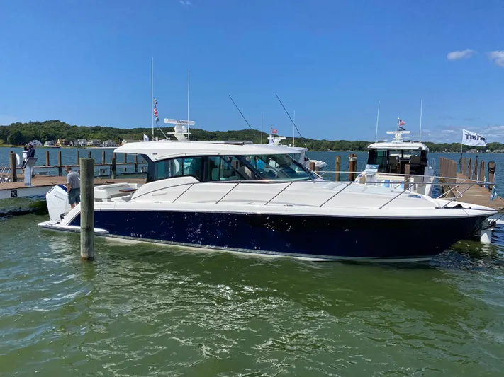  Yacht Photos Pics 2025 Tiara Yachts 43 LE docked in a marina, blue hull, sunny day.