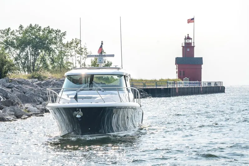 Yacht Photos Pics 2025 Tiara Yachts 43 LE near a red lighthouse on a sunny day.