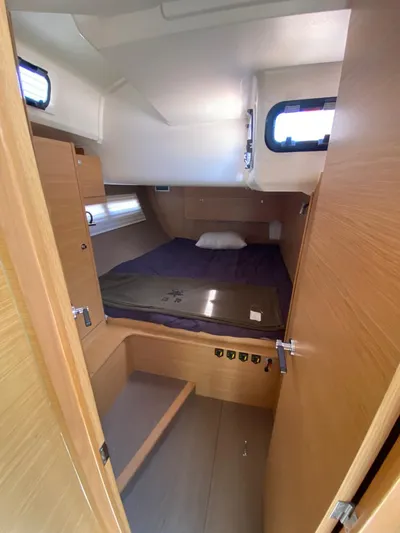  Yacht Photos Pics 2017 Dufour Exclusive 56 yacht cabin with bed, wooden interior, and porthole windows.