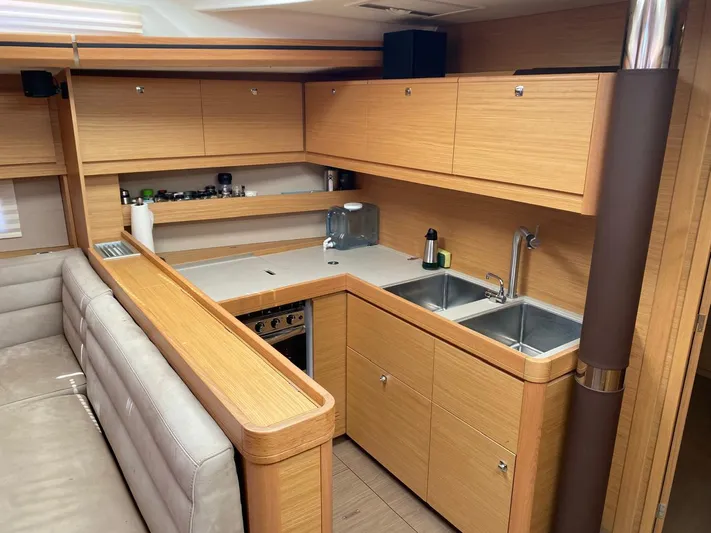  Yacht Photos Pics Modern kitchen interior of 2017 Dufour Exclusive 56 yacht, featuring wood cabinetry and dual sinks.